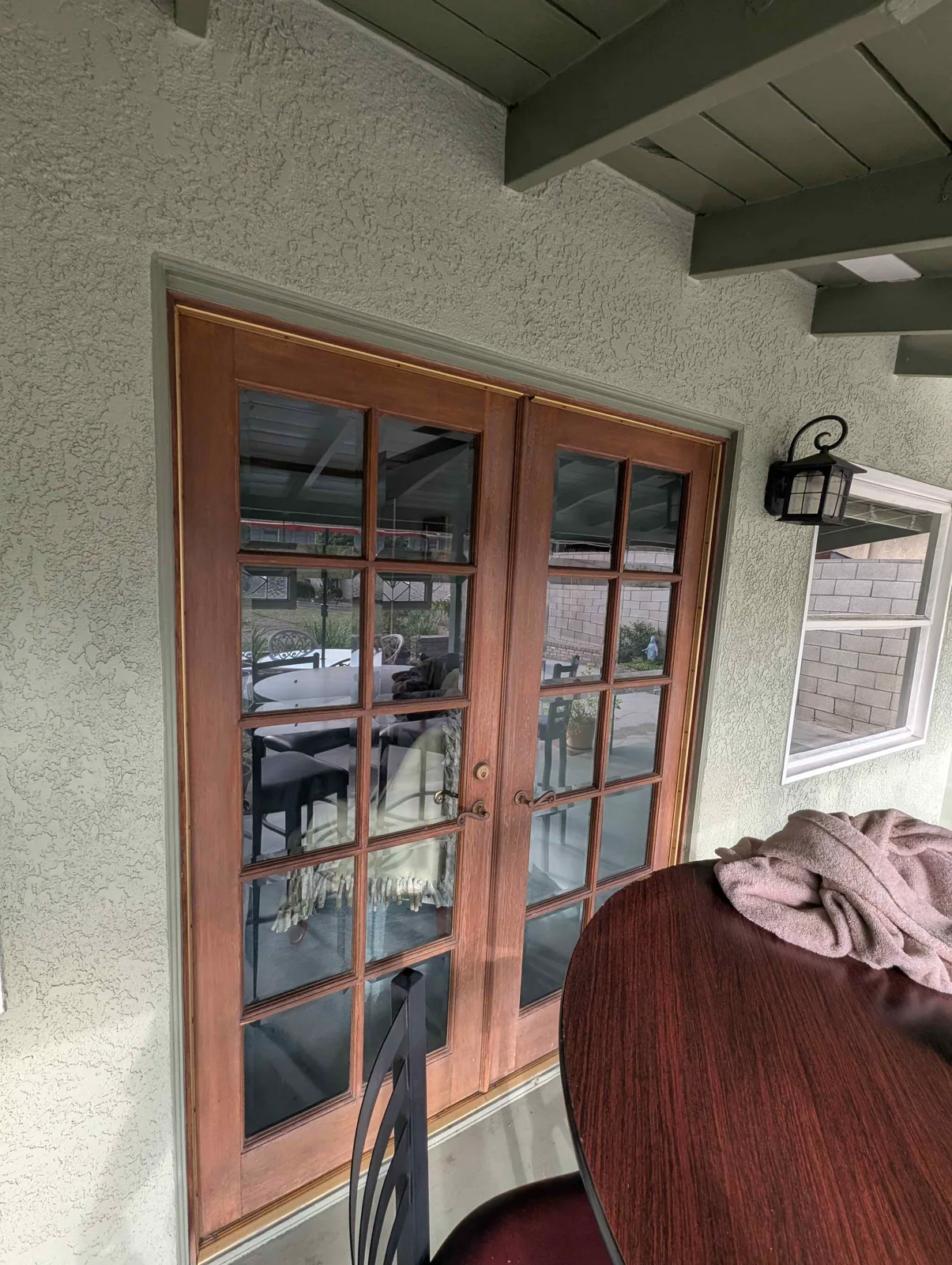 Wood French doors with fifteen glass panes each after cleaning, covered patio