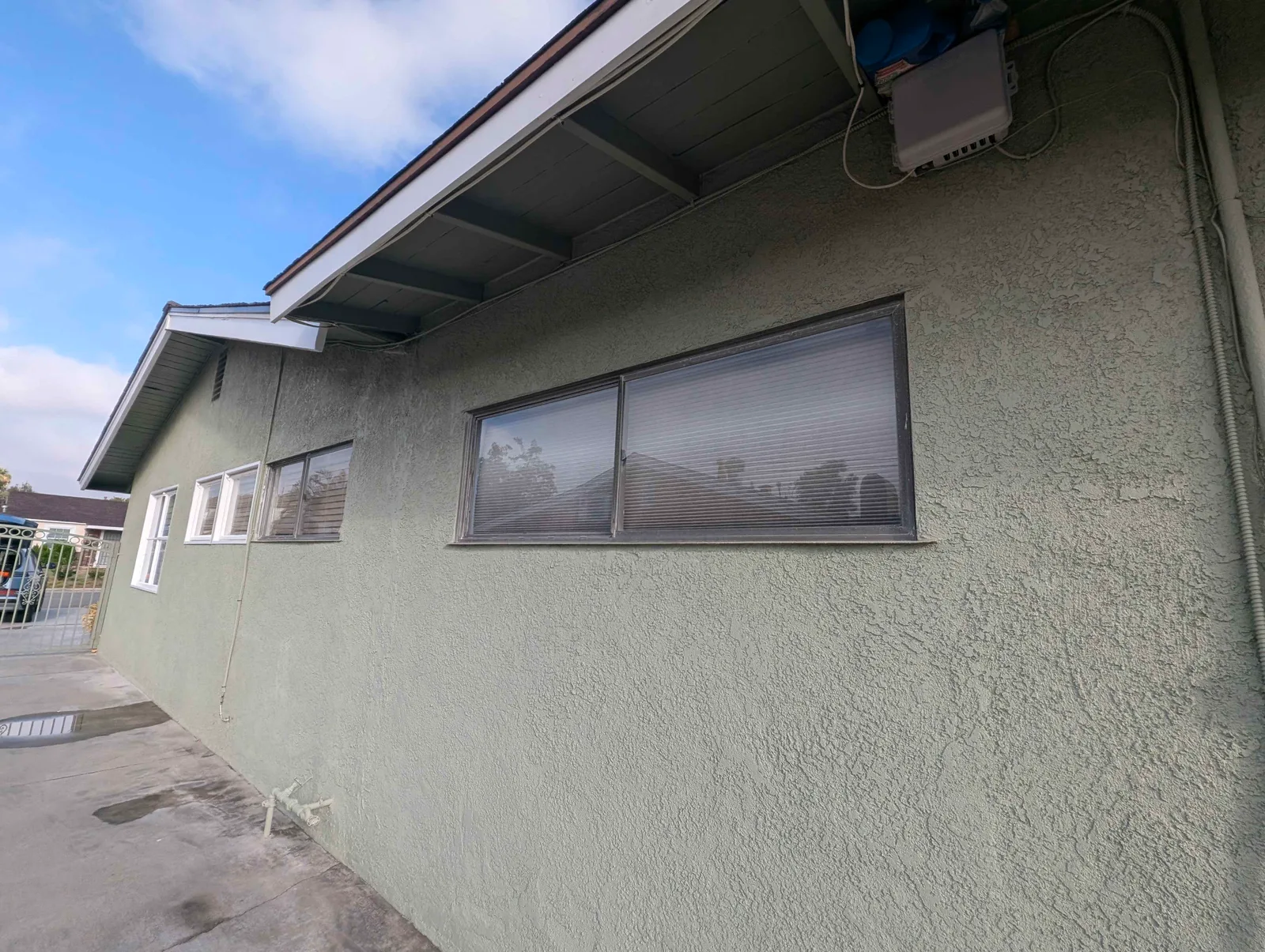 Row of side windows on a stucco home after exterior cleaning